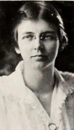 A young white woman wearing glasses and a white blouse