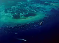 Aerial view of a coral reef including a ship aground