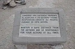 A warning sign on a rock, telling to stay away from the vents and to be responsible