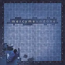 A blue photo of a man building a big puzzle