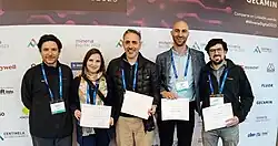 Wise stands holding a publication certification with fellow BHP Authors at Mineria Digital 2023