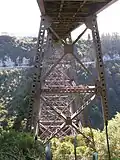 The piers that support the plate girder bridge, seen from under the eastern abutment. State Highway 2 traverses the opposite bank.