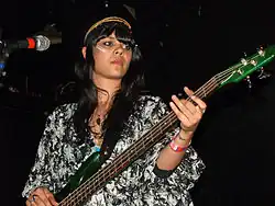 A picture of a woman playing a bass guitar