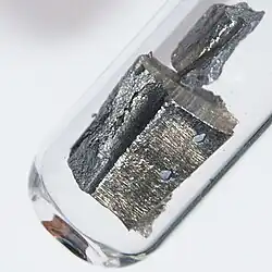 A piece of silvery metal in a glass tube