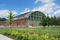 The rear of the armory, with a green wall and many windows in the upper section