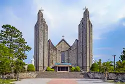 A cathedral in modernist style. It has 3 main sections with the main one being curved and sandwiched by the two other towering sections.