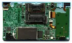 A large and small printed circuit board connected together. A metal chassis and main electronic components dominate opposite ends of the large PCB.