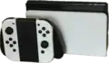 A Nintendo Switch – OLED Model in docked mode with White Joy-Con controllers in grip
