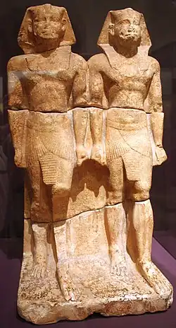 Duo of statues representing the king as a young and old man, standing with a sword