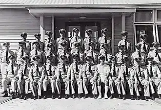 Group portrait of uniformed staff in front of building