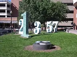 Several tall Arabic numerals standing upright in a lawn