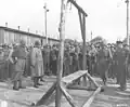 An Austrian-Jewish survivor points out the gallows to General Dwight D. Eisenhower.