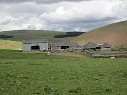 A picture of a farm in Old Hazeltonrig with Castle Hill pictured to the right.
