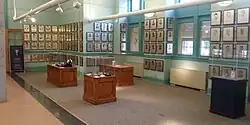 Large hallway with multiple display cases and plaques mounted on the walls