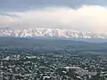 Panorama of Osh showing high, snow-capped peaks of the Alay Range to the south of city