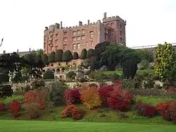 a large red sandstone building overlooking a series of terraces