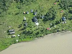 Scattered buildings along the shore of the Mackenzie River.