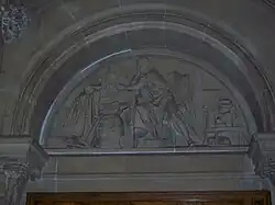 Carved stone tympanum showing Richard Arkwright apparently making calculations alongside experimental models of the water frame
