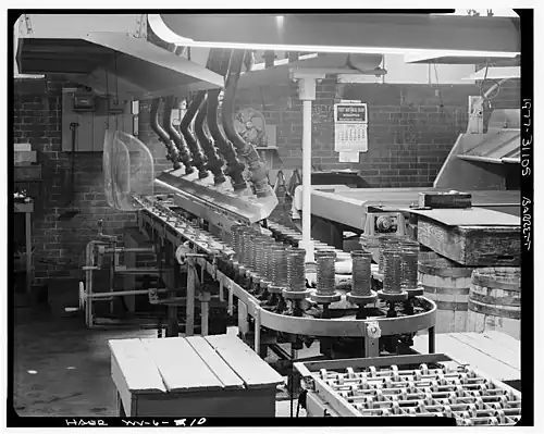 machinery with glassware on it and conveyer to oven