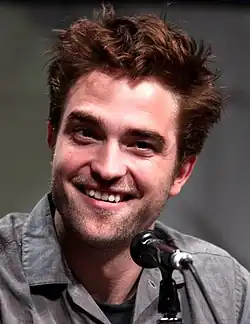 Pattinson smiling behind a microphone