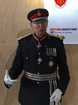 A uniformed man speaks in a dimly lit room at a sports club prizegiving