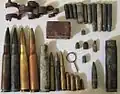 Artifacts found at the former Sahuarita Air Force Range, including a 20 mm anti-aircraft gun casing and belt link, M2 bullets and casings, M1919 bullets, casings, and a machine gun belt link, M1 Garand bullets, casings, and a stripper clip, M1 Carbine bullets and casings, M1911 bullets and casings, a .22 bullet and casing, some unidentified casings, and an Mk 2 grenade pin.