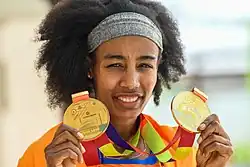 Hassan holds up her two gold medals.