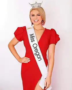 Sophia Takla in crown and sash, wearing a red dress