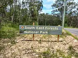 Photograph of an official sign for the national park at one of its road boundaries using the pluralised word, "forests".