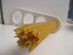 Dried spaghetti measured with a "spaghetti measure". One portion of dried pasta weighs 116 g (4+1⁄8 oz), twice the amount of one serving on the package (12 mm circle or 60 g.). The measure can portion out 1, 2, 3 or 4 servings based on the diameter of the circle.