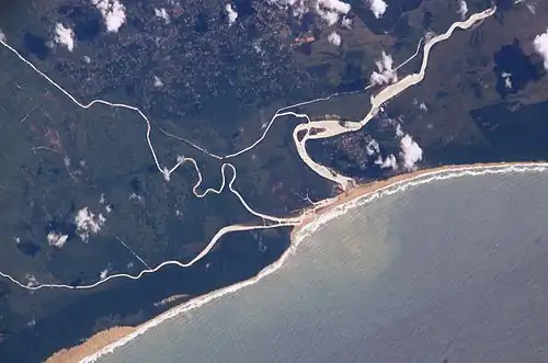 The old and new courses near the mouth, with the Msunduzi converging from the left (i.e. south), enclosing a wetland. Also note the silt plume at sea.