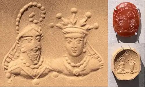 Stamp seal with a bearded figure in Sasanian dress, wearing the kulāf denoting nobility and officials; and a figure with radiate crown,[112] both with royal ribbons. Attributed to the Hephthalites,[113] and recently dated to the 5th–6th century AD.[114] Stamp seal (BM 119999), British Museum.