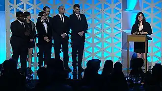 A group of adults on stage accepting an award.