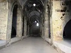A long stone chamber with a curved vaulted roof and other rooms opening on either side