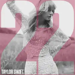 Cover artwork of "22" by Taylor Swift has the number "22" in red, in the foreground, behind the number is a black and white photo Taylor on a grassy field
