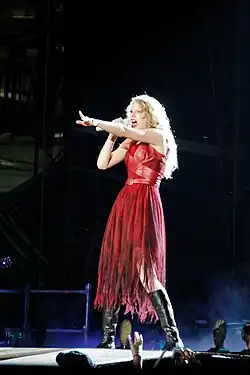 Taylor Swift on the Speak Now World Tour, singing with a mic and dressed in red