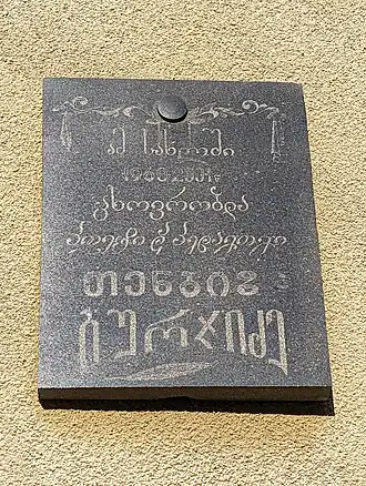 A commemorative plaque using Mkhedruli for the upper four lines and Mtavruli for the lower two (the name of the person), with each line written in a different typeface
