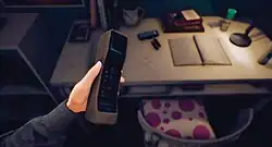 Image depicts Nicole's left hand holding up a mobile phone from her point-of-view.