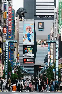 Many movie and advertisements of media are in the top of a skyline in Japan; some people look up to them