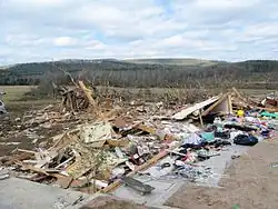 A photo showing a home swept off its foundation in the Super Tuesday tornado outbreak. Scattered parts of the structure can be seen lying on top of the foundation. The damage from this tornado would be rated EF4.