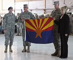 Photograph of Jan Brewer with three soldiers