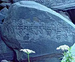 Om mani padme hum -variation of the six syllable mantra of Avalokiteshvara.[3] is inscribed in Tibetan script[4] on this rock behind the main building.