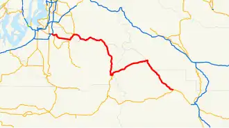 A map of the Cascade Range northeast of Mount Rainier and the surrounding foothills depicting the route of State Route 410 (SR 410, highlighted in red) between Sumner at SR 167 and Naches at U.S. Route 12 (US 12). This was one of the sections that made up US 410, which existed from 1926 until 1967, being replaced with US 12.