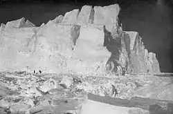 High cliffs of an iceberg set in broken pack ice