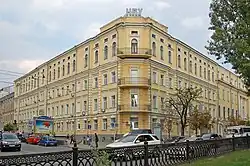 Photograph of the corner facing of a four-story building made of yellow block