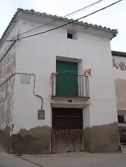 Casa del pueblo con puerta de madera labrada