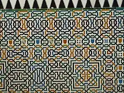 Sala de Dos Hermanas; azulejos con cintas pintadas en azul, verde, melado y morado, hecho sobre estaño, donde se entremezclan los escudos de banda nazaríes