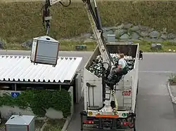 Vehículo vaciando un contenedor de vidrio.