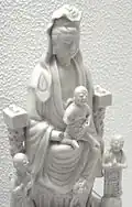 Guanyin (Bodhisattva de la Compasión) con niños; "China blanca" estatuilla de Dehua.