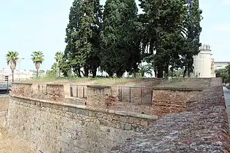 Lienzo al oeste con troneras defendiendo el foso y Puerta de Palmas al fondo